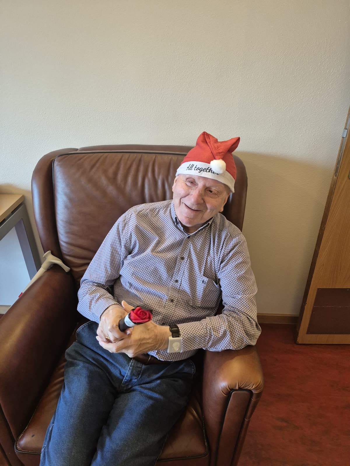 Een bewoner met kerstmuts en knuffel