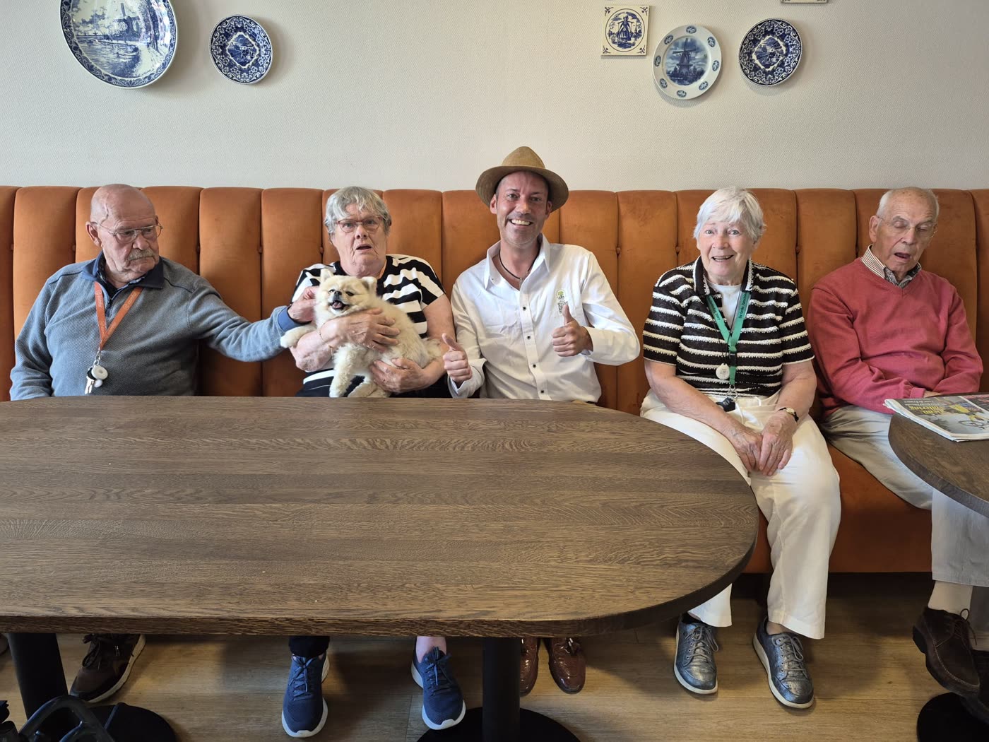 Bewoners en een vrijwilliger samen aan tafel
